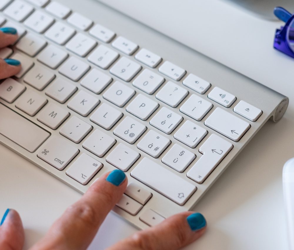 Working at home with computer, woman writing a blog. Female hands on keyboard